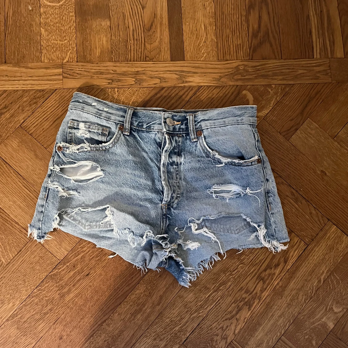 Ljusa slitna jeansshorts med fransar