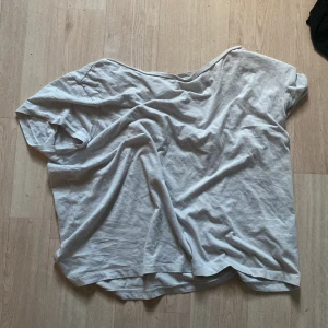 Oversized ljusgrå t-shirt - En oversized ljusgrå t-shirt med avslappnad passform och korta ärmar. T-shirten har en enkel design och är tillverkad i mjukt bomullstyg, perfekt för en chill och bekväm stil.