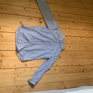 Randig skjorta från Ralph Lauren - Klassisk skjorta från Ralph Lauren i blåvitt randigt mönster. Skjortan är i storlek xs och är 165-170. Skjortan har lång ärm, knappar framtill och broderad logga på bröstet. Modellen är custom fit och tillverkad i mjuk bomull. Perfekt för en clean och stilren look. Priset går o ändras!