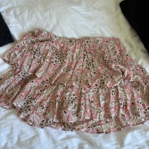 Rosa mönstrad volangkjol från Zara - Supersöt kort kjol från Zara i rosa med blommigt och paisleymönster. Kjolen har flera volanger och en flowy passform. Knappt använd💕