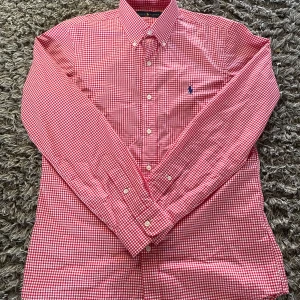 Rutig Ralph Lauren skjorta – S - 🧼 Skick: Mycket bra skick, sparsamt använd. Inga fläckar eller hål. 📏 Storlek: S 🎨 Färg: Röd och vit (gingham-mönster) 👕 Modell: Långärmad button-down från Ralph Lauren 📍 Detaljer: Klassisk preppy skjorta med broderad logga på bröstet. Passar både till vardag och mer uppklädda tillfällen. 📫 Frakt: Skickas snabbt och välpackat. 💬 Frågor? Tveka inte att skriva om du vill ha fler bilder eller mått! 