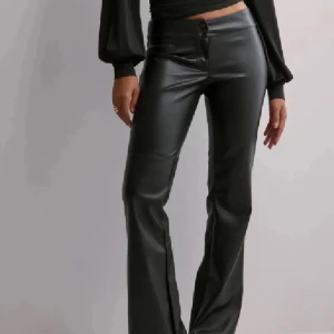 Lågmidjade skinnbyxor  - Utsålda svarta lågmidjade bootcut skinnbyxor från Nelly. Helt nya och oanvända, endast testade med lapparna kvar. Nypris 499kr +49kr frakt. Passar någon i längden från 165cm och neråt. Säljer då jag köpte två storlekar. Tryck gärna på köp nu. 