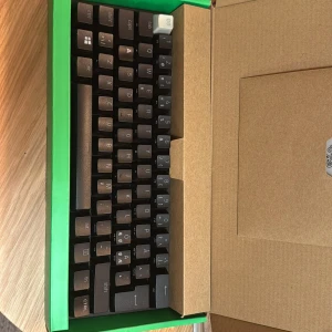 Razer Huntsman Mini  - Följer med sladd, klistermärken och instruktionsbok. Det är lila clicky optimal switches