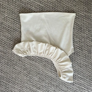 Vit oneshoulder tubtopp med volang - Supersnygg vit tubtopp i oneshoulder-modell med bred volangdetalj längs axeln. Toppen har en stilren, modern look som passar perfekt till jeans eller kjol. Mjuk och stretchig för en bekväm passform.