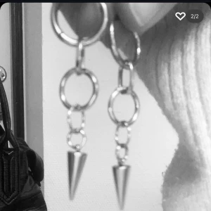 Silvriga örhängen med kedjor och spikes - Coola silvriga örhängen med kedjor och spetsiga spikes längst ner. De har flera ringar som länkas ihop och avslutas med en konformad detalj. Perfekta för dig som gillar edgy och unik stil.