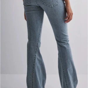 True Religion Joey  - Snygga true religion Joey jeans i ljusblå med klassiska bakfickor och markerade sömmar. Jeansen har en lätt utsvängd passform nertill och sitter skönt över höfterna. Perfekta för en avslappnad och trendig look. St 25