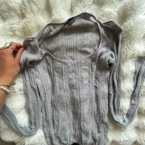 Grå ribbad stickad tröja Gina Tricot - Supersnygg grå stickad tröja från Gina Tricot med ribbat mönster och lång ärm. Tröjan har en rundad halsringning och är i ett tunt, luftigt material som passar perfekt till lager-på-lager. Enkel att styla till jeans eller kjol.