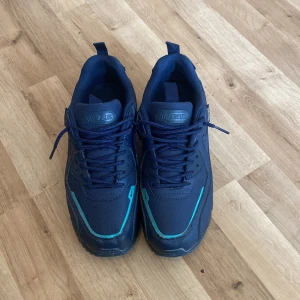 Nike Air Max 90 Cordura marinblå - Säljer ett par Nike Air Max 90 i marinblått Cordura-tyg med snygga detaljer i turkos. Skorna har klassisk Air Max-sula, snörning och diskret Nike-logga på sidan. Perfekta för dig som gillar streetstyle och vill ha något som sticker ut.