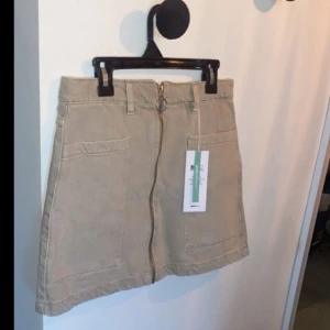 Ginatricot - Denim zip skirt - Helt oanvänd jeanskjol med dragkedja framtill, se bild 3 för att se hur den ser ut på (tagen från ginatricots hemsida). I strl 34 (XS). Erbjuder rabatt vid köp av 2 eller fler produkter!
