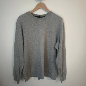 Grå crewneck från Nike SB med dragkedja - Grå crewneck-tröja från Nike SB med diskret logga på bröstet. 