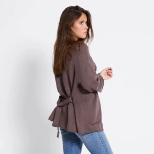 Ny! Brun kofta med knytband  ”Colette” - Mysig brun kofta från Colette i oversized modell med breda ärmar och snygg knytning i ryggen. Koftan är stickad och har en öppen front, perfekt att slänga över en t-shirt eller linne. Passar dig som gillar en chill och trendig look.