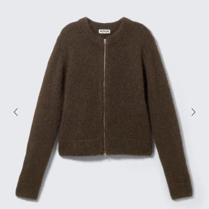 Brun stickad kofta från Weekday - Mysig brun stickad kofta från Weekday med rak passform och hel dragkedja framtill. Koftan har rund halsringning och långa ärmar, perfekt att slänga på sig över en t-shirt eller linne. Enkel och stilren design som funkar till det mesta.