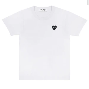 Vit Comme des Garçons Play t-shirt - Vit t-shirt från Comme des Garçons Play med klassisk svart hjärtlogga på bröstet. Enkel och clean design med rund hals och korta ärmar. Perfekt för dig som gillar stilrena plagg med en twist. Köpte på Miinto för 900kr