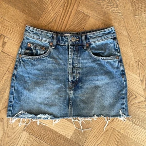 Blå jeanskjol med fransig kant - Säljer en fin jeanskjol från Sara i storlek S som jag har köpt på vinted. Den har en liten skavank på bakfickan och så är lappen bortdragen men annars i fint skick!