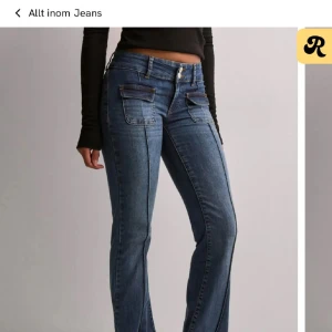 Blå jeans med fickdetaljer - Snygga blåa boot cut jeans med fickor framtill. Jeansen har klassisk midja och markerade sömmar längs benen för en cool look. 