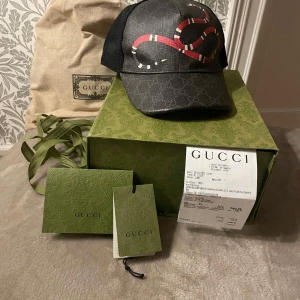 Gucci keps kingsnake svart - Säljer min Gucci keps då jag ej använder den längre. Kvitto box och alla tags medföljer. Storlek s/57 cm.