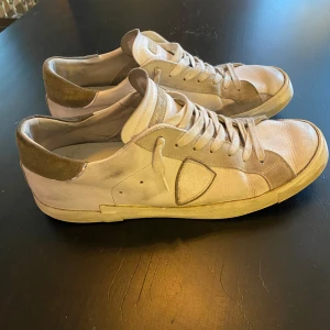 Philippe Model skor - Snygga sneakers från Philippe Model i vitt och grått. Skorna har en klassisk design med snörning och en bekväm passform. Perfekta för en stilren vardagslook. De passar 45-46