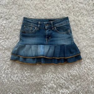 Jeanskjol med volang - En lågmidjad jeanskjol omsydd från ett par jeans. Midjemått tvärsöver- 32cm (stretchig) Längd- 32cm