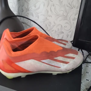 Röd och vita fotbollsskor från Adidas - Röda vita adidas crazyfast elite skor .köpte de ungefär för 3 månader sen och det är i jätte bra skick inga skador. Och jag köpte de från unisport för 1699kr och säljer de för 799 för de har blivit små