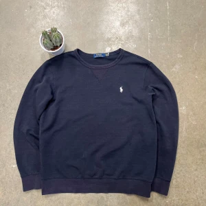 Ralph Lauren Tröja  - Säljer denna snygga och tidlösa sweatshirt från Polo Ralph Lauren i en mörkblå färg. Perfekt för en avslappnad men stilren look!  🏷 Detaljer: 	•	Storlek: Mellan M & L (se mått nedan) 	•	Färg: Mörkblå 	•	Material: Troligtvis 100 % bomull eller en mjuk bomullsblandning 	•	Skick: Mycket bra skick – inga synliga fläckar eller hål  En riktigt skön och mångsidig tröja som passar till det mesta! ✨ Skickas snabbt och väl förpackad.  📩 Hör av dig vid frågor! 