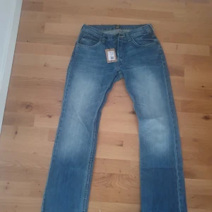 Blå jeans från Lee - Snygga blå jeans från Lee i klassisk denimstil. De har en normal passform och är perfekta för en avslappnad look. Byxorna har en traditionell femficksdesign och en läderpatch med Lee-loggan på baksidan.