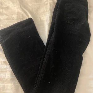 Svarta manchesterbyxor - Snygga svarta manchesterbyxor med en klassisk look. Perfekta för en stilren och bekväm outfit. Byxorna har en rak passform och en praktisk ficka bak.