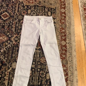 Vita jeansbyxor - Snygga vita jeansbyxor med en klassisk femficksdesign. De har en knapp och dragkedja framtill. Perfekta för en stilren look.