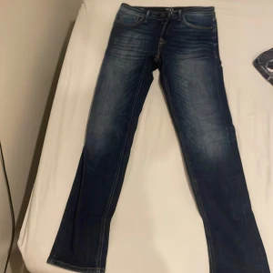 Mörkblå jeans från Jack & Jones - Snygga mörkblå jeans från Jack & Jones med en klassisk femficksdesign. De har en normal passform och är tillverkade i slitstarkt denim. Perfekta för en avslappnad stil. Nypris 699 sek, mitt pris 450 sek.