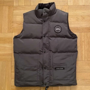 Grå canada goose väst black label - Säljer helt ny och oanvänd canada goose black label väst i storleken M. Pris går att diskutera vid snabbaffär!