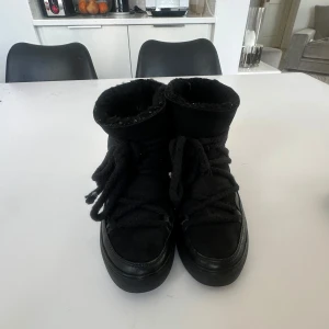 Svarta boots med foder - Säljer ett par svarta boots från Inuikii med varmt foder. Skorna har snörning framtill och är perfekta för kyligare väder. De är tillverkade i skinn och har en stilren design som passar till det mesta.