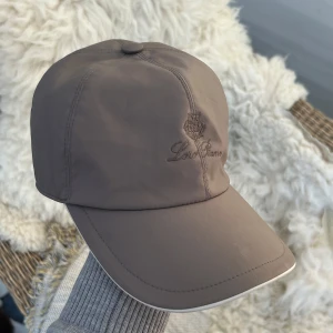 Loro piana storm system keps - Snygg gråbrun keps från Loro Piana med broderad logga framtill. Kepsen har en elastisk baksida för bättre passform.