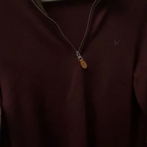 Morris vinröd half zip  - Säljer en stilren vinröd tröja från Morris i 100% merinoull. Tröjan har en dragkedja framtill och en liten broderad logga på bröstet. Perfekt för kyligare dagar. Pris går att diskutera 