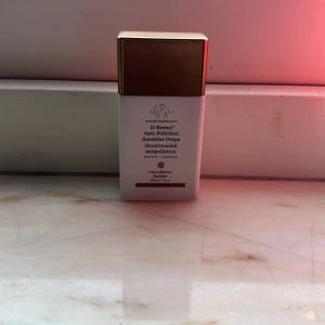 D-Bronzi Anti-Pollution Sunshine Drops - D-Bronzi Anti-Pollution Sunshine Drops från Drunk Elephant i en vit flaska med guldlock. Innehåller 30 ml och är designad för att ge en solkysst look samtidigt som den skyddar mot föroreningar. Perfekt för att blanda med din dagkräm eller foundation för extra lyster.