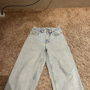 Ljusblå jeans från Polar Skate Co. - Säljer ett par ljusblå jeans från Polar Skate Co. med en avslappnad passform. De har en klassisk femficksdesign och en snygg broderad logga på fickan. Perfekta för en casual look!