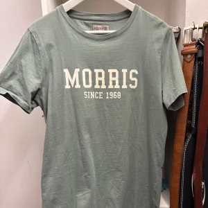 Grön t-shirt från Morris - Snygg grön t-shirt från Morris med texten 'Morris Since 1968' tryckt på framsidan. Perfekt för en avslappnad stil. Tillverkad i mjukt material för extra komfort.