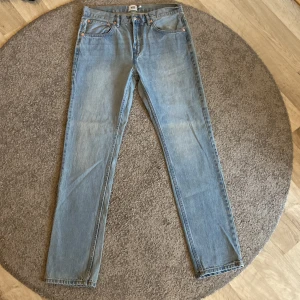 Ljusblå raka jeans  - Säljer ett par klassiska ljusblå jeans med raka ben och fem fickor. Jeansen har normal passform och är tillverkade i denim. Perfekta för en avslappnad stil. Helt oanvända! 