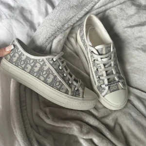 Christian Dior Skor - Säljer ett par grå och vita sneakers från Christian Dior. Snygga och perfekta nu till sommaren. Kommer bli nya trenden inför sommaren!🤩Storlek på skorna är: 37 och skicket är så gott som nya! Hör av dig vid frågor🙏💕