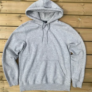 Grå hoodie från H&M - Säljer en ljusgrå hoodie från H&M i relaxed fit. Tröjan har huva med dragsko och en stor magficka framtill. Perfekt för en avslappnad stil och enkel att matcha med det mesta. Storlek xs, har en fläck vid snöret som syns på bild 3. Skicka ett meddelande vid frågor eller funderingar💫