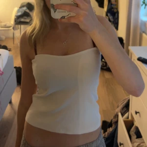 Vit ribbad tubtopp från Gina Tricot - Säljer en vit ribbad tubtopp från Gina Tricot. Toppen är ärmlös och har en enkel, stilren design som passar perfekt till sommaren. Materialet är stretchigt och bekvämt. Storlek M men passar mig som vanligtvis har XXS-XS. Köpte 2022 och har knappt använt den❣️
