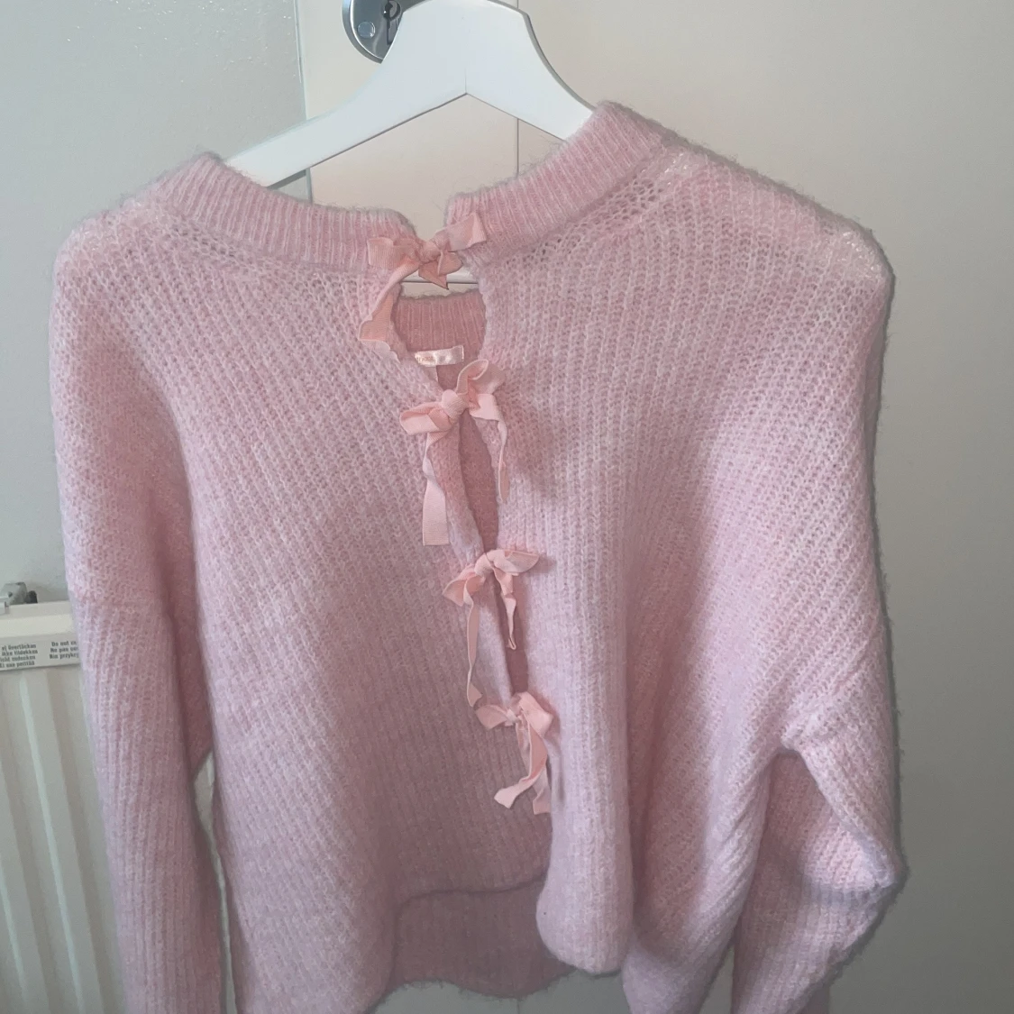 Rosa stickad tröja med rosetter