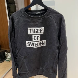 Svart sweatshirt från Tiger of Sweden - Säljer en clean sweatshirt från tiger of sweden. Perfekt all around tröja. Väl använd. Hojta vid funderingar! 