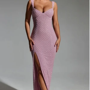 Rosa glittrig långklänning med slits - Säljer en rosa långklänning med glittrigt mönster, djup v-ringning och hög slits framtill, öppen rygg med två tunna band baktill. Perfekt för dig som vill sticka ut på festen! Passar s/xs. Pris kan diskuteras. 