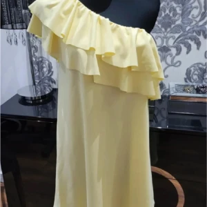 Gul one shoulder klänning med volang !!😇❤️ - Snygg gul klänning med one shoulder-design och stora volangdetaljer längs axeln. Säljer denna klänningen då den var för stor men inga fläckar eller hål, mycket bra skick då prislappen finns kvar !!😇🥰 OBS! Köpt på Plick och säljer för samma pris. Inte min bild nr 1 och nr 3