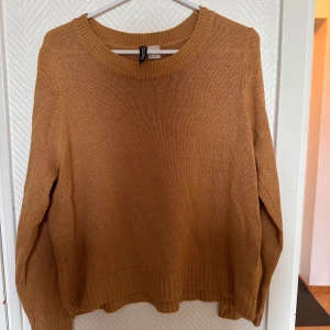 Beige stickad tröja från H&M Divided - Mysig beige stickad tröja från H&M Divided. Tröjan har rund halsringning, långa ärmar och ribbade muddar vid ärmslut och nederkant. Perfekt för lager-på-lager och enkel att matcha med olika outfits.