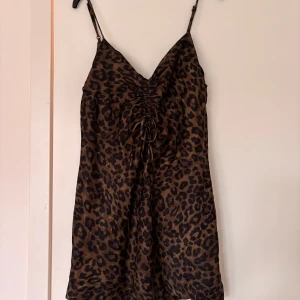 Leopardmönstrad klänning från ZARA - Säljer en snygg leopardmönstrad klänning från ZARA i storlek XS. Klänningen har smala axelband, omlottdetalj framtill och knytning vid bysten. Defekt på snöret, de andra bilden💓