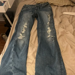 Blå slitna bootcut jeans - Säljer ett par blå bootcut jeans me hål, från gina tricot, jätte fina aldrig använda 