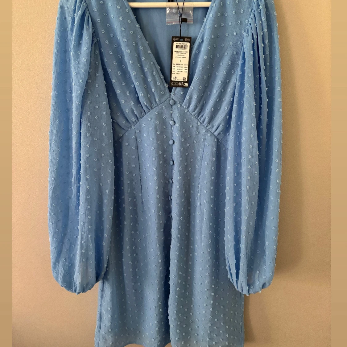 Ljusblå klänning med prickigt mönster