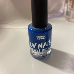 Blått UV-nagellack från Splashes & Spills - Snyggt blått UV-nagellack från Splashes & Spills. Kommer i en klassisk glasflaska med svart lock. Perfekt för att skapa coola nagellooks som lyser under UV-ljus.