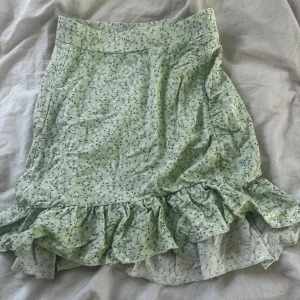 Ljusgrön blommig kjol med volang från Gina Tricot - Supersöt ljusgrön kjol från Gina Tricot med små blommor och volang nertill. Perfekt för vår och sommar! Säljer då den är för liten, använt endast några gånger ❤️
