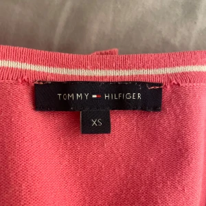 Rosa långärmad tröja från Tommy Hilfiger🤍 - Säljer en rosa långärmad tröja från Tommy Hilfiger i storlek XS. Tröjan har en enkel och klassisk design med rund halsringning och är tillverkad i ett mjukt material som känns skönt mot huden. Tröjan har ett litet streck på högra ärmen (se bild 3), därav priset. Skriv om ni vill ha en närmare bild på märket🫶🏻